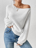 Model wearing a white off-the-shoulder long sleeve ribbed knit sweater paired with blue jeans.