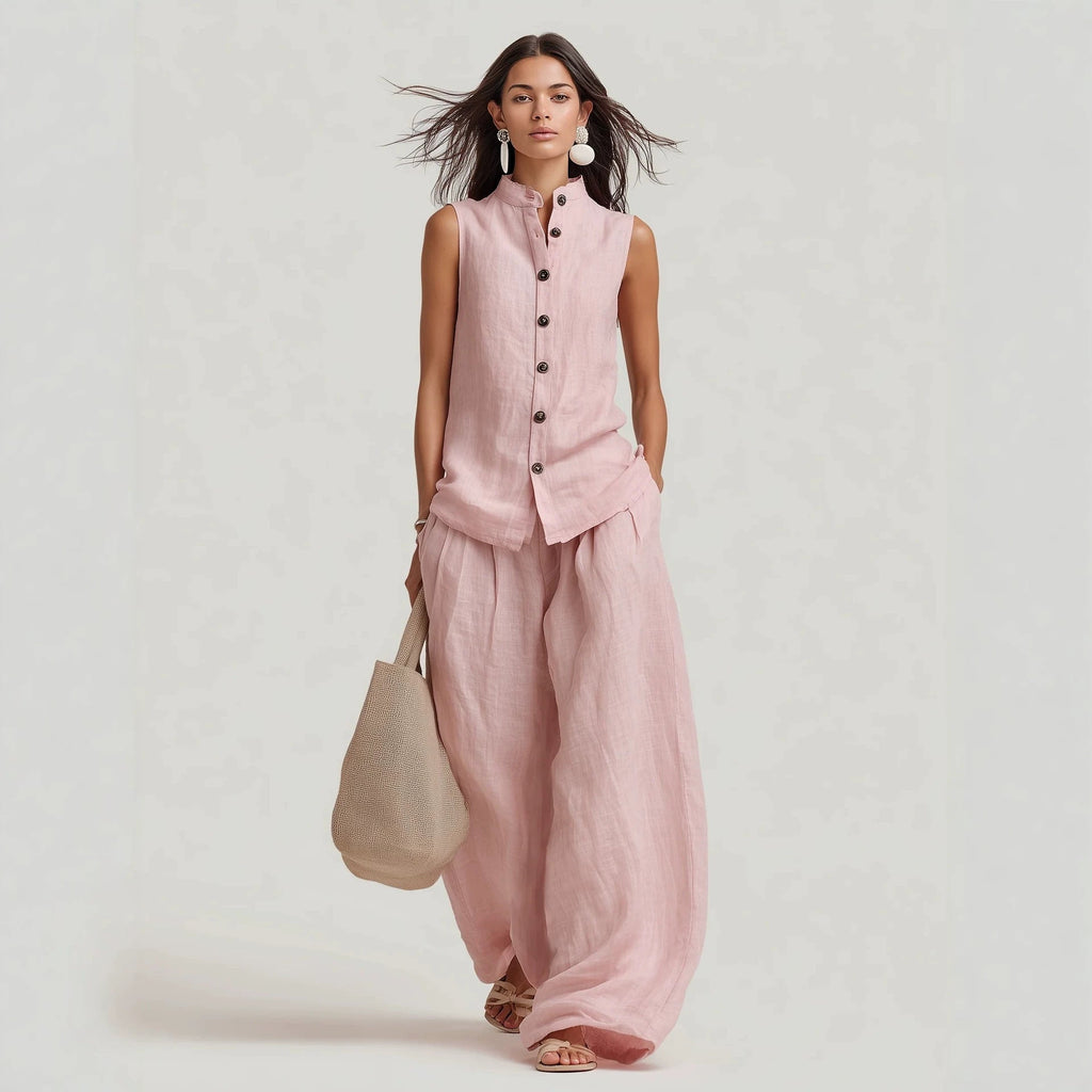 A woman wearing a sleeveless button-down top with a stand collar and matching high-waisted wide-leg pants, available in pink and burgundy.