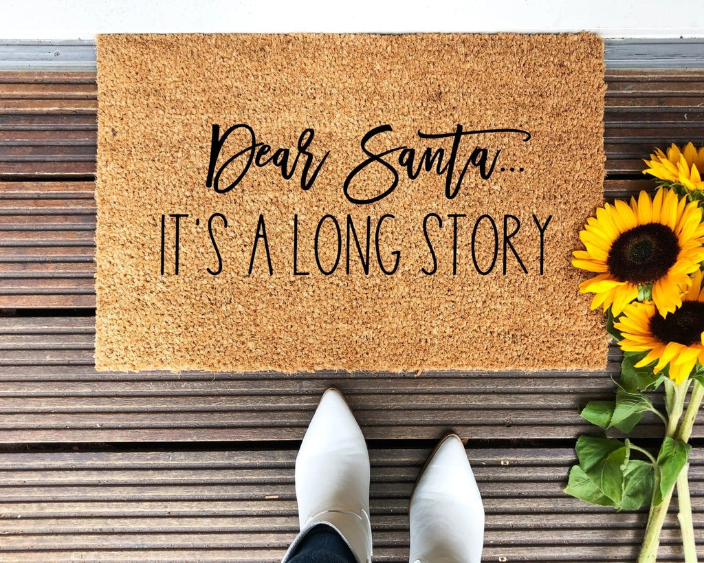 Farmhouse style natural coir doormat with text reading Dear Santa, It's A Long Story on a front porch