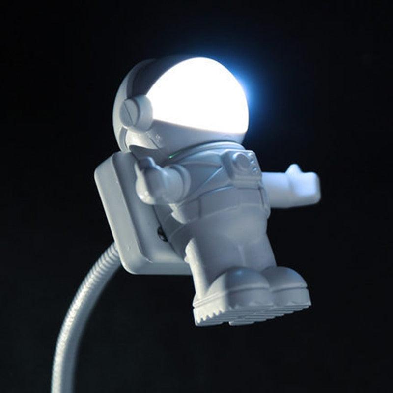 Playful white astronaut-themed LED desk lamp with a flexible gooseneck arm.