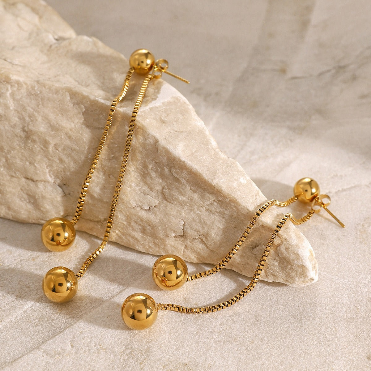 18K gold earrings featuring elegant round beads and dangling tassel chains