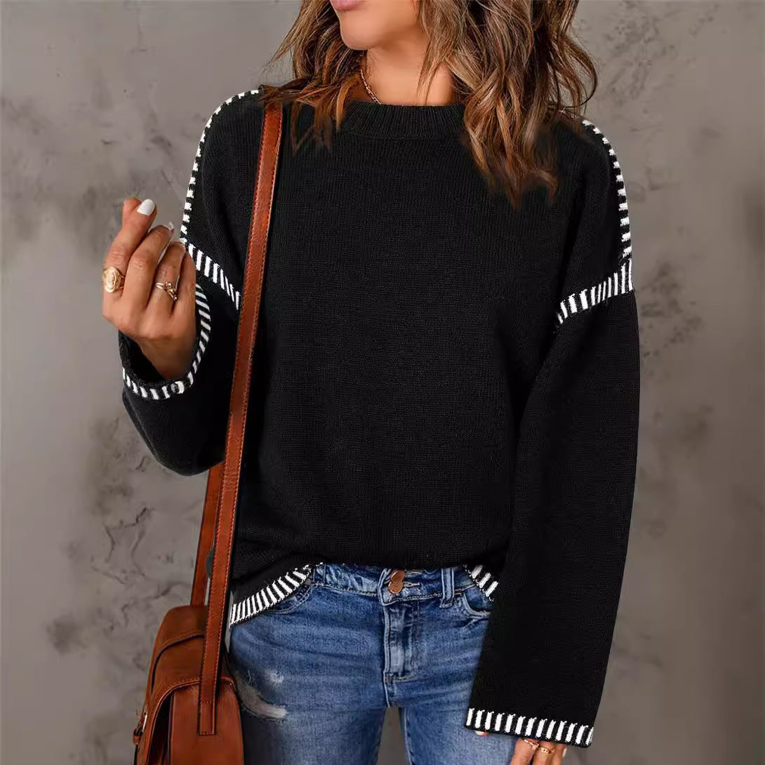 A woman wearing a loose-fitting solid round neck pullover sweater with flared sleeves.