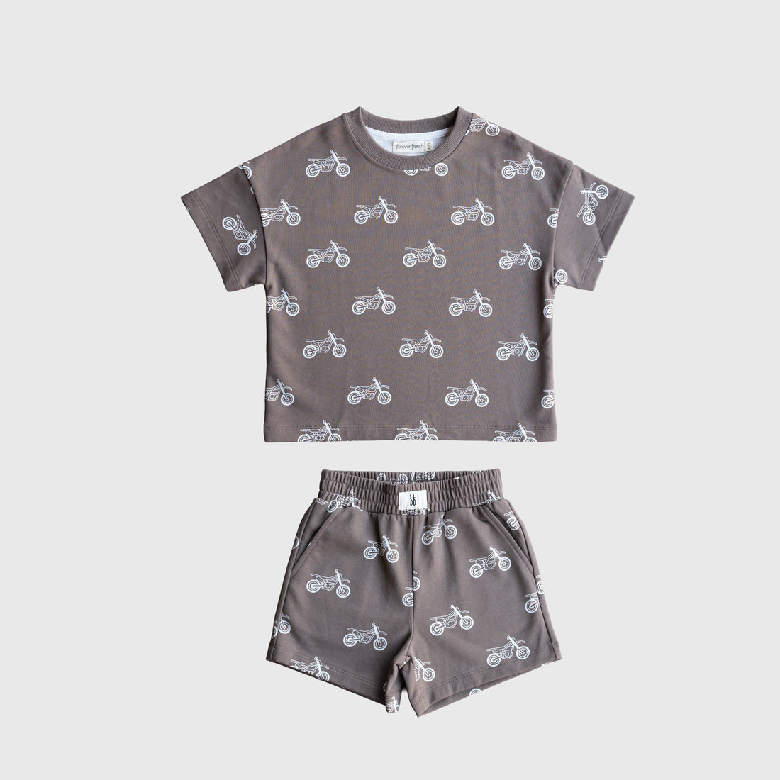 Child wearing a grey and white dirt bike graphic French terry short set