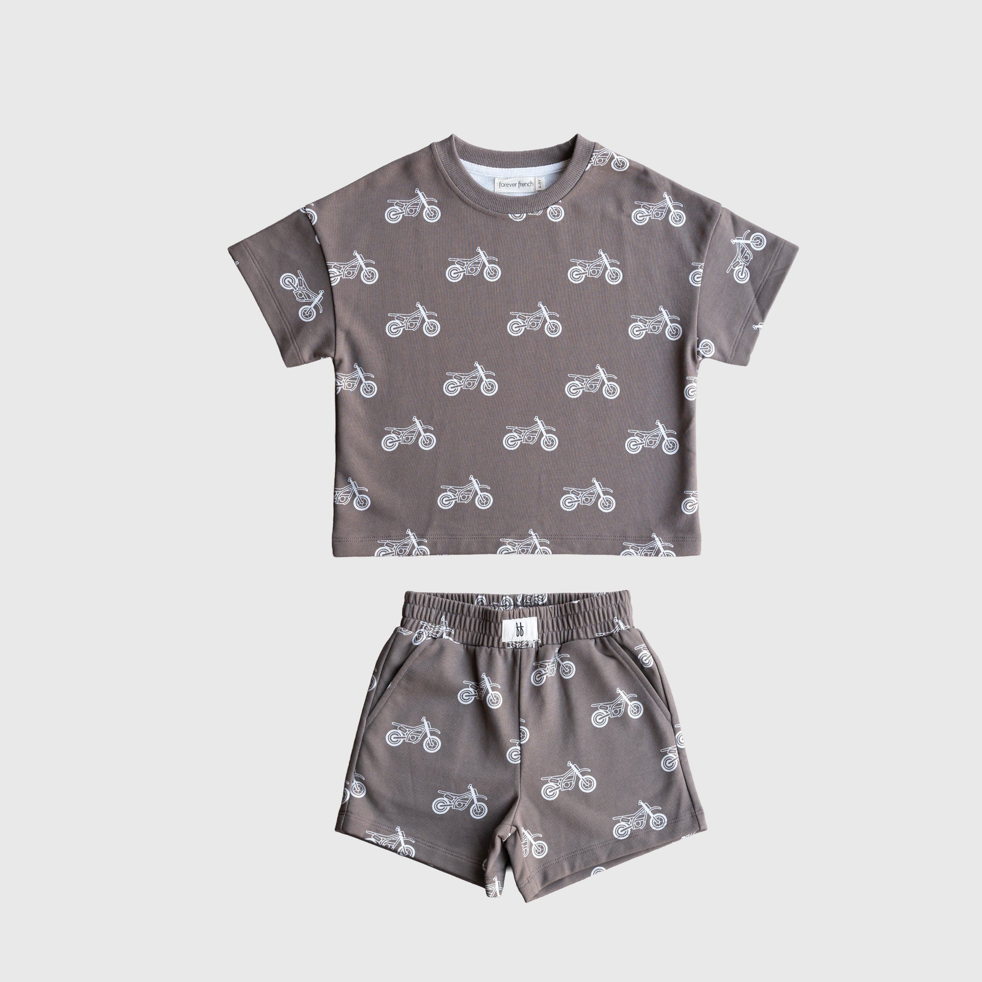 Child wearing a grey and white dirt bike graphic French terry short set