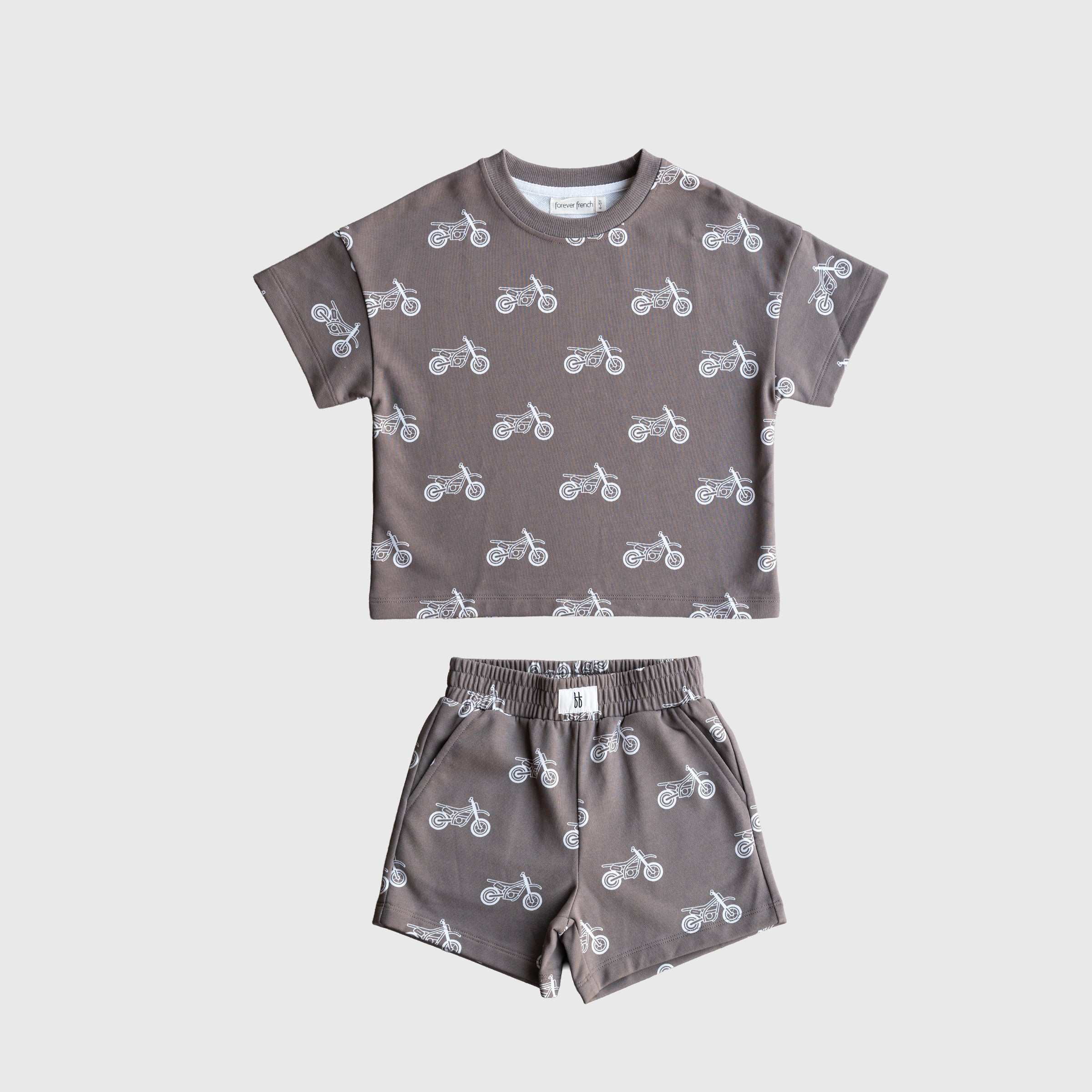 Child wearing a grey and white dirt bike graphic French terry short set