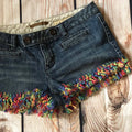DIY Upcycled Fringe Jean Short Kit with colorful yarn and instructions for customizing denim shorts.