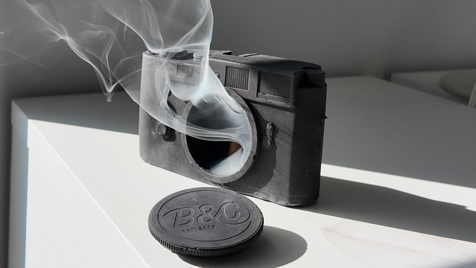 A grey and white concrete Analog Camera sculpture, minimalist desk decor