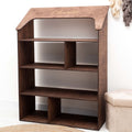 A gender-neutral, house-shaped Montessori bookcase in a bright nursery setting for toy and book storage.