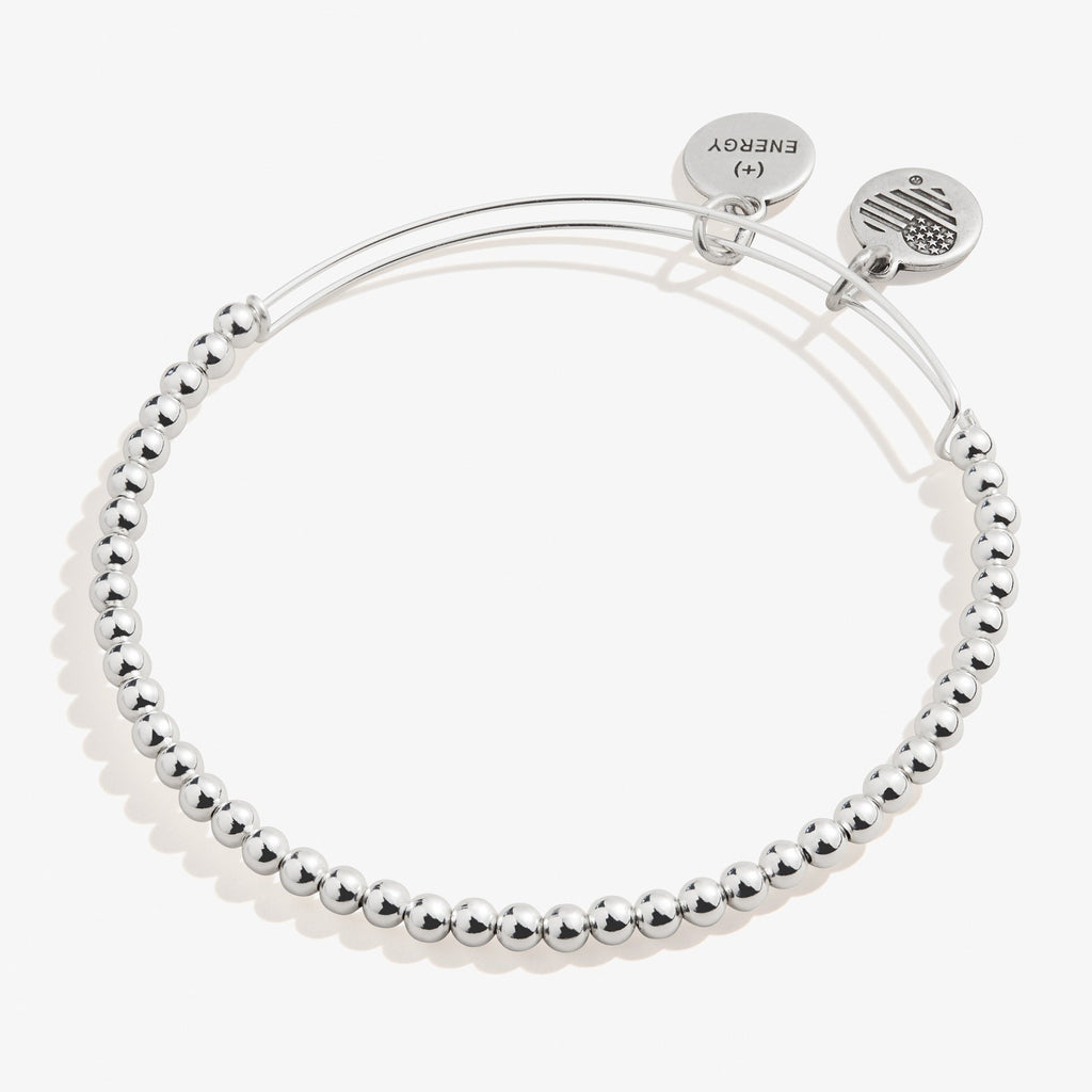 Minimalist dot beaded bracelet available in gold and silver finish on a neutral background