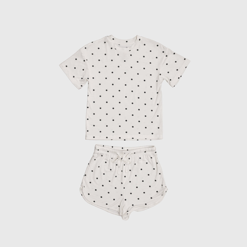 Girl wearing Annie bamboo short set in creamy off-white with charcoal polka dots