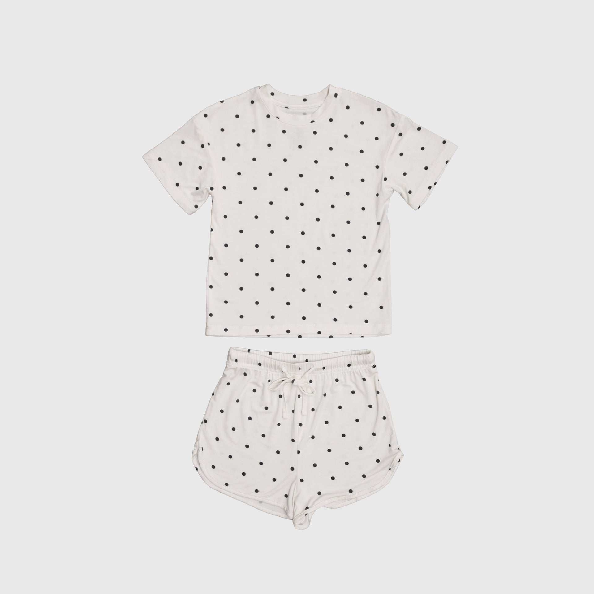 Girl wearing Annie bamboo short set in creamy off-white with charcoal polka dots