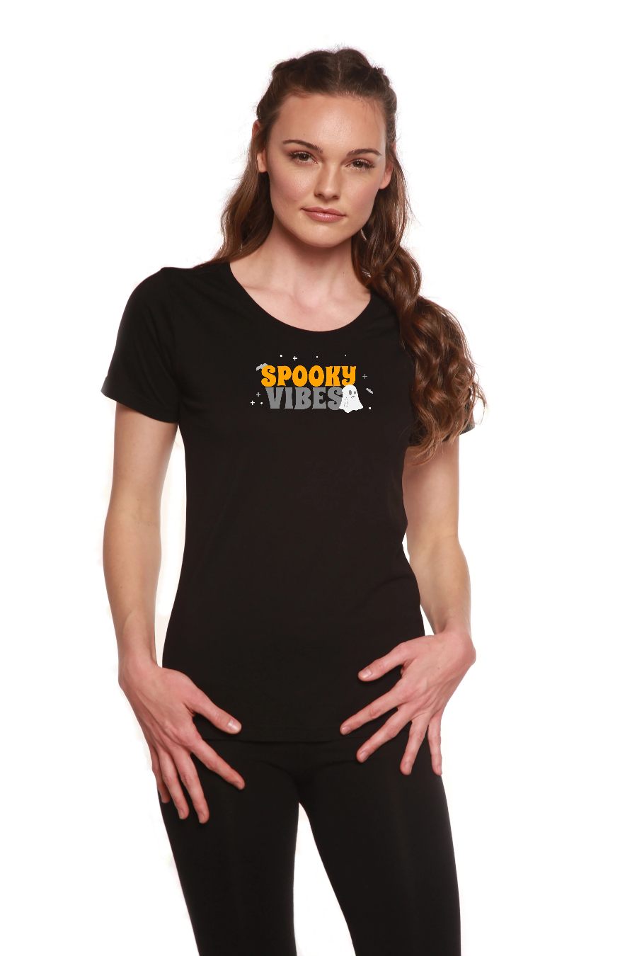 A woman wearing a black short sleeve t-shirt with a Spooky Vibes graphic print on the front, featuring a scoop neck design.