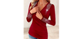 A woman wearing a red long-sleeve knit top with V-neckline and decorative rhinestones on shoulders and sleeves.