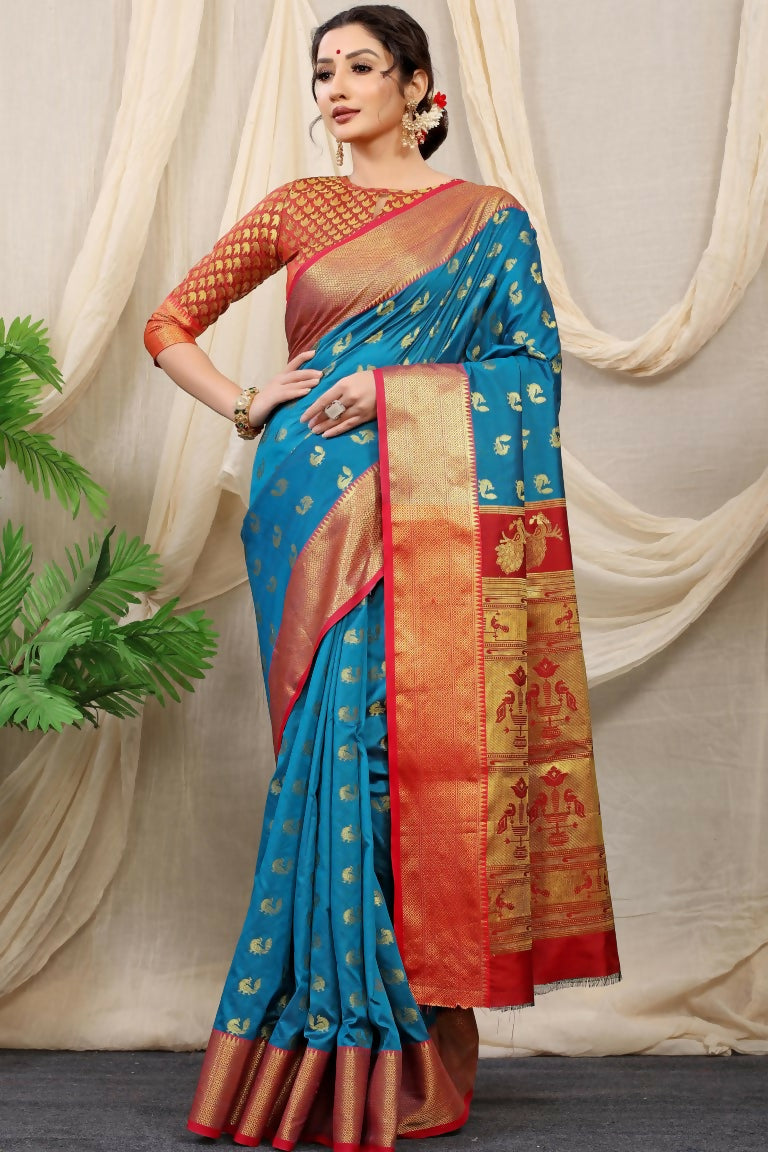 A Firozi Banarasi silk saree with intricate gold zari weaving and a contrast red blouse draped elegantly.