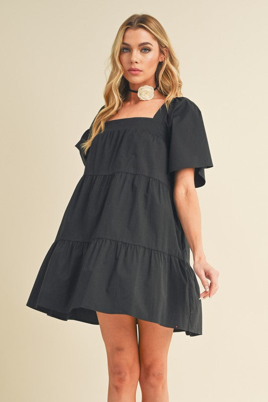 Woman wearing a stylish square neck tiered summer dress with half sleeves