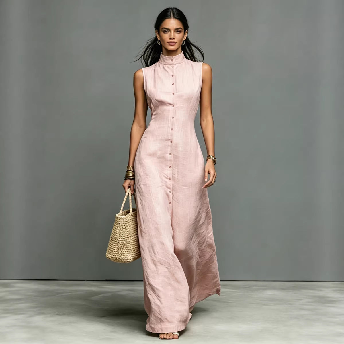 Model wearing a light pink sleeveless midi dress with a stand collar and button-front closure against a grey studio background