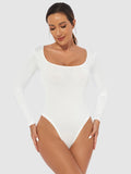 A model wearing a plain white long-sleeved bodysuit with a scoop neckline against a light gray background.