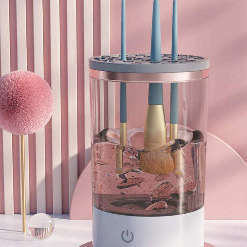 Portable white and rose-gold electric makeup brush cleaner machine on a vanity