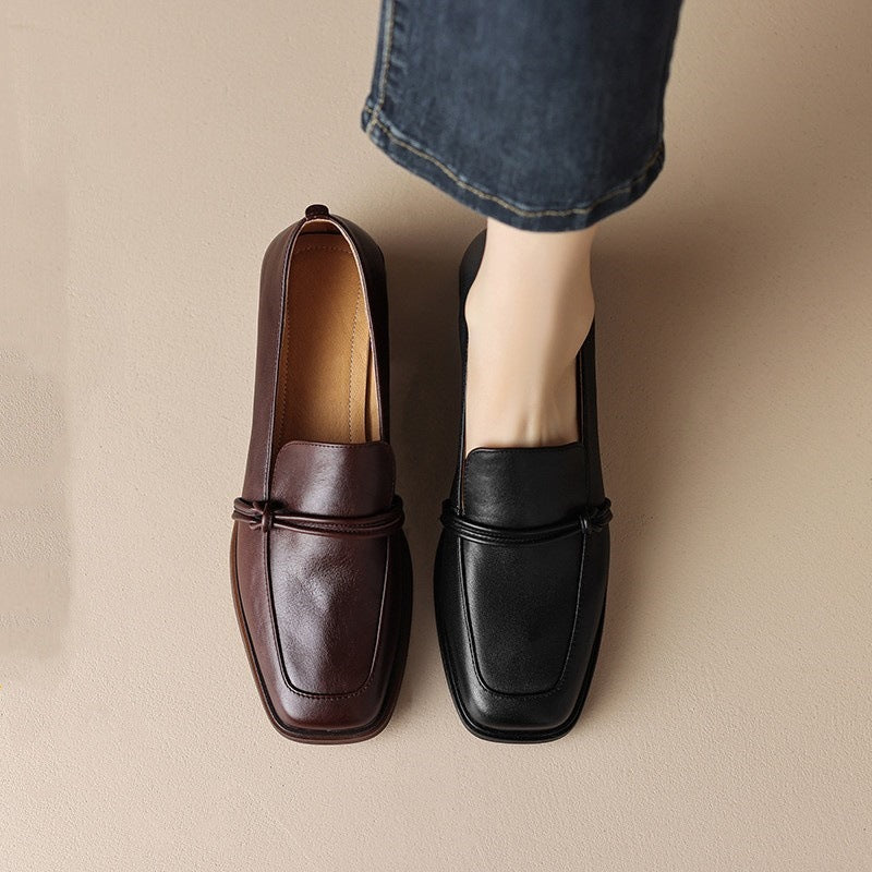 A pair of retro minimalist mid-heel leather loafers in black and brown displayed on a neutral background.