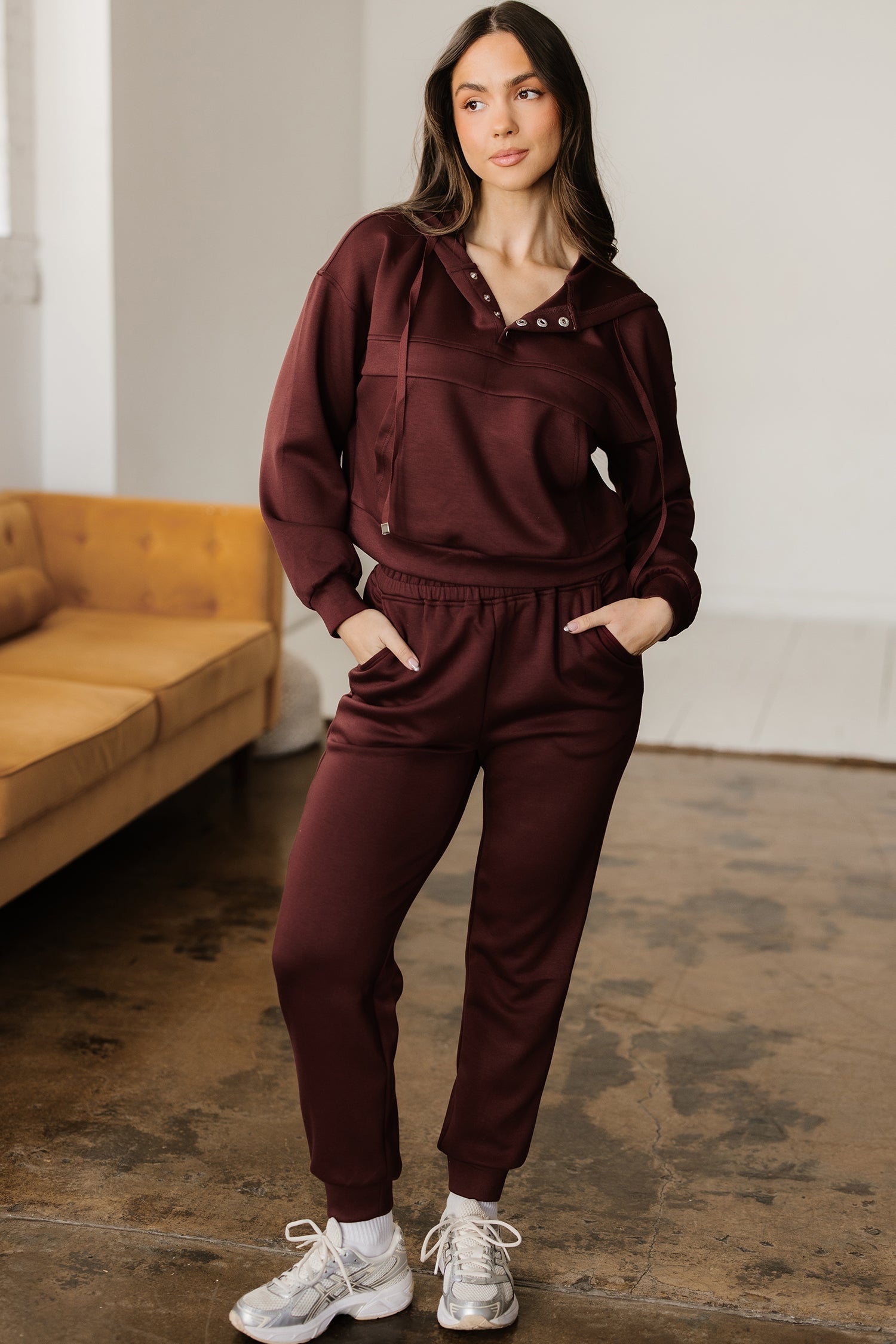 A woman wearing a modern cropped hoodie and matching jogger pants in a comfortable lounge set