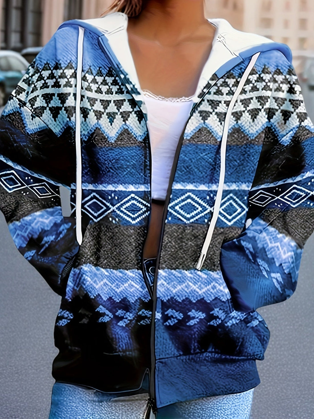 A woman wearing a vibrant blue tribal print zip-up hoodie with a drawstring hood and long sleeves.