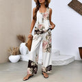 Woman wearing a white sleeveless tank top and wide-leg trousers set with 3D floral print and black hem contrast