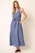 Model wearing a flattering V-neck tank maxi dress with a belted waist and unique cross-back detail.