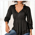 Woman wearing a long sleeve dual-layer V-neck blouse with ruffle trim detail.