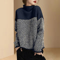 A woman wearing a cozy mock neck sweater with a navy and cream chevron pattern on a soft knit fabric.