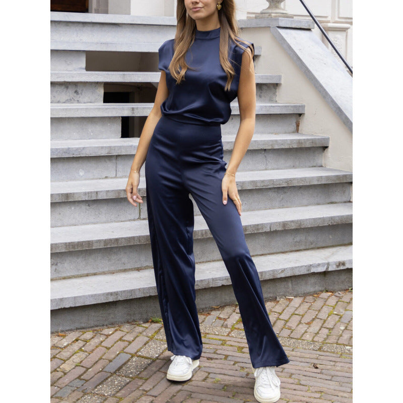 Woman wearing a sleek, backless satin wide-leg jumpsuit in a rich jewel tone for a formal party look.