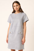 Woman wearing a minimalist grey short sleeve suede mini dress with a round neck