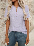 Purple short sleeve top featuring eyelet fabric detail and a notched neckline with a decorative button