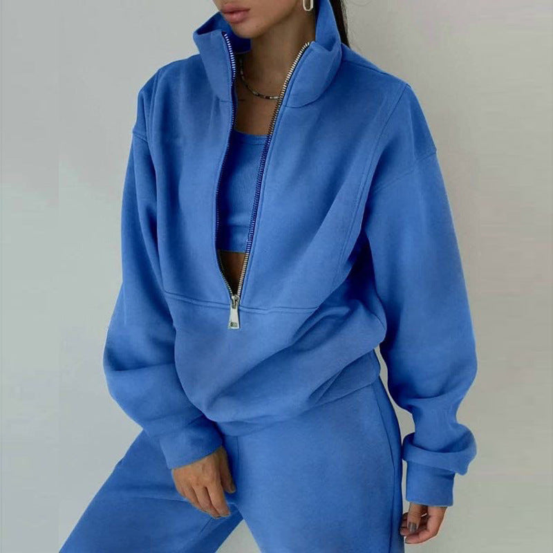 A woman wearing a matching 2-piece set with a zip-neck sweatshirt and slim-fit pants available in blue and tan colors.