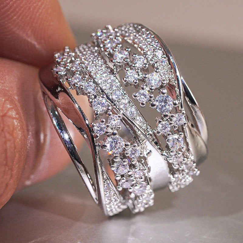 Close up of a geometric platinum-plated ring with cubic zirconia inlay on a woman's finger
