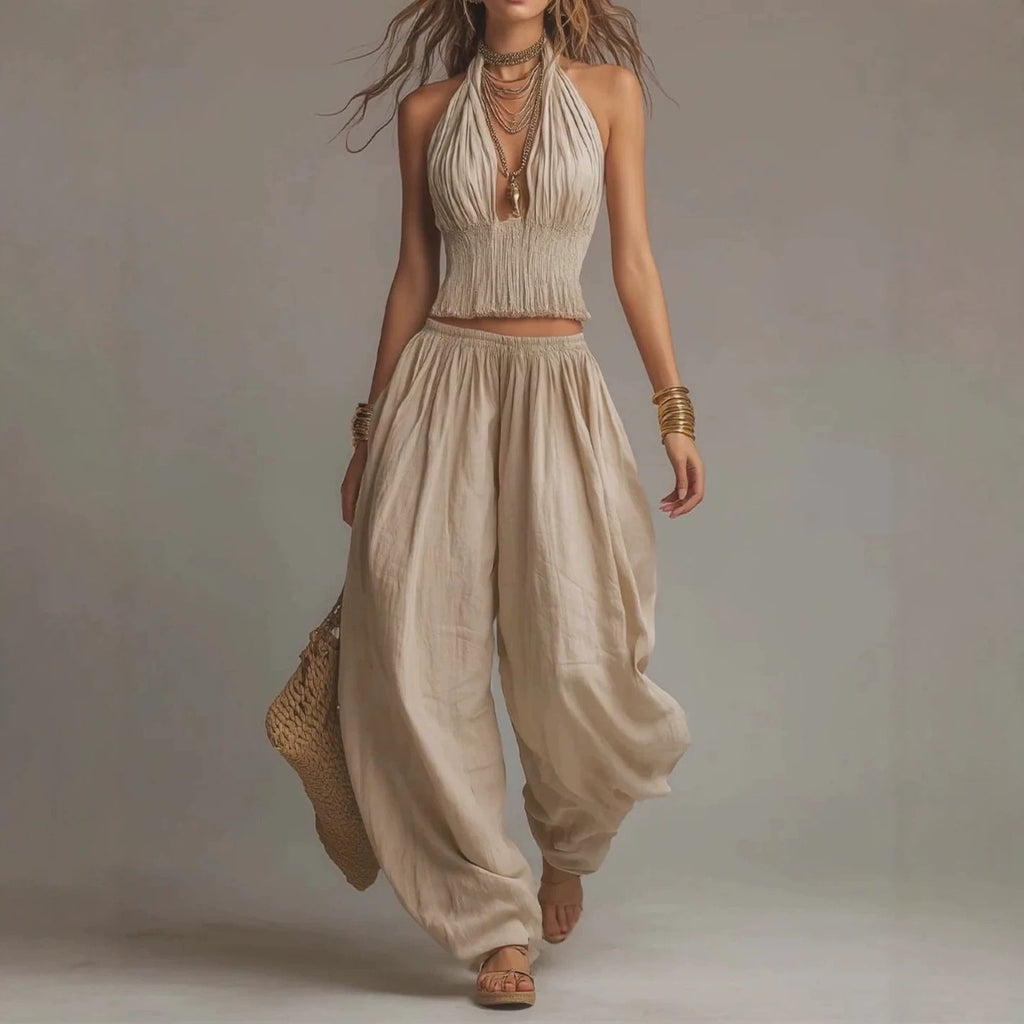 Model wearing a backless halter top and wide-leg linen pants set in beige.