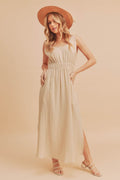 A beige sleeveless maxi tank dress with side slits and a round neckline.