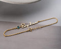 Personalized cursive name bracelet with a round bezel-set birthstone on a delicate cable chain