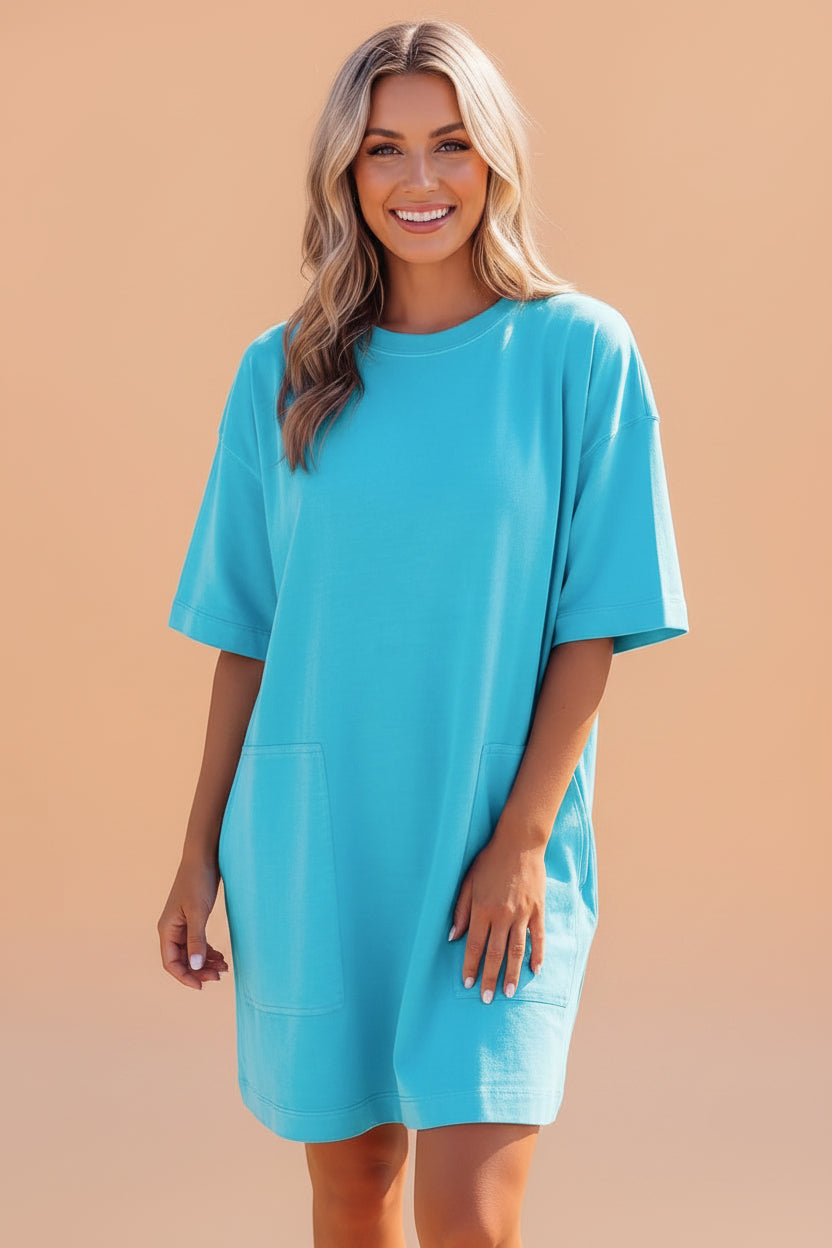 Model wearing a bright blue oversized cotton crew neck drop shoulder mini t-shirt dress with side pockets