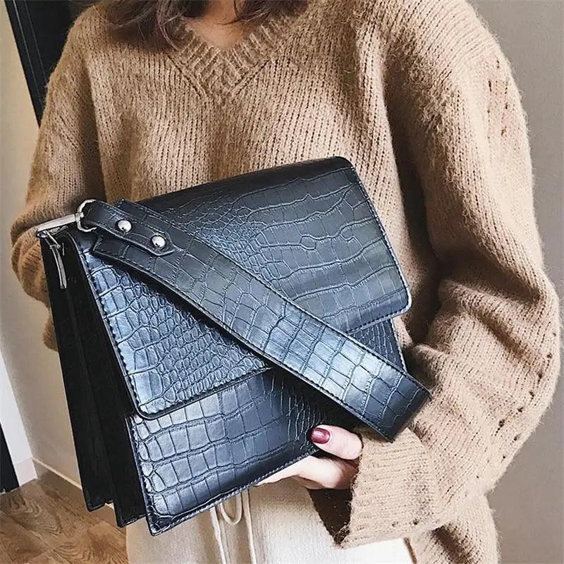 Modern girls' messenger bag with a glossy patent-look finish and gold-tone chain strap.