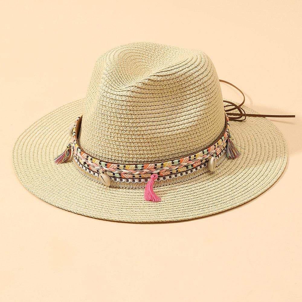 Elegant straw bucket hat with tassel detail, available in beige and black for summer beach travel.