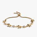 Adjustable gold and silver tone bolo bracelet with elephant charms and crystal accents