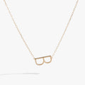 Close-up of the Initial B Precious Elongated Necklace featuring a sideways letter charm with cubic zirconia on a gold chain.