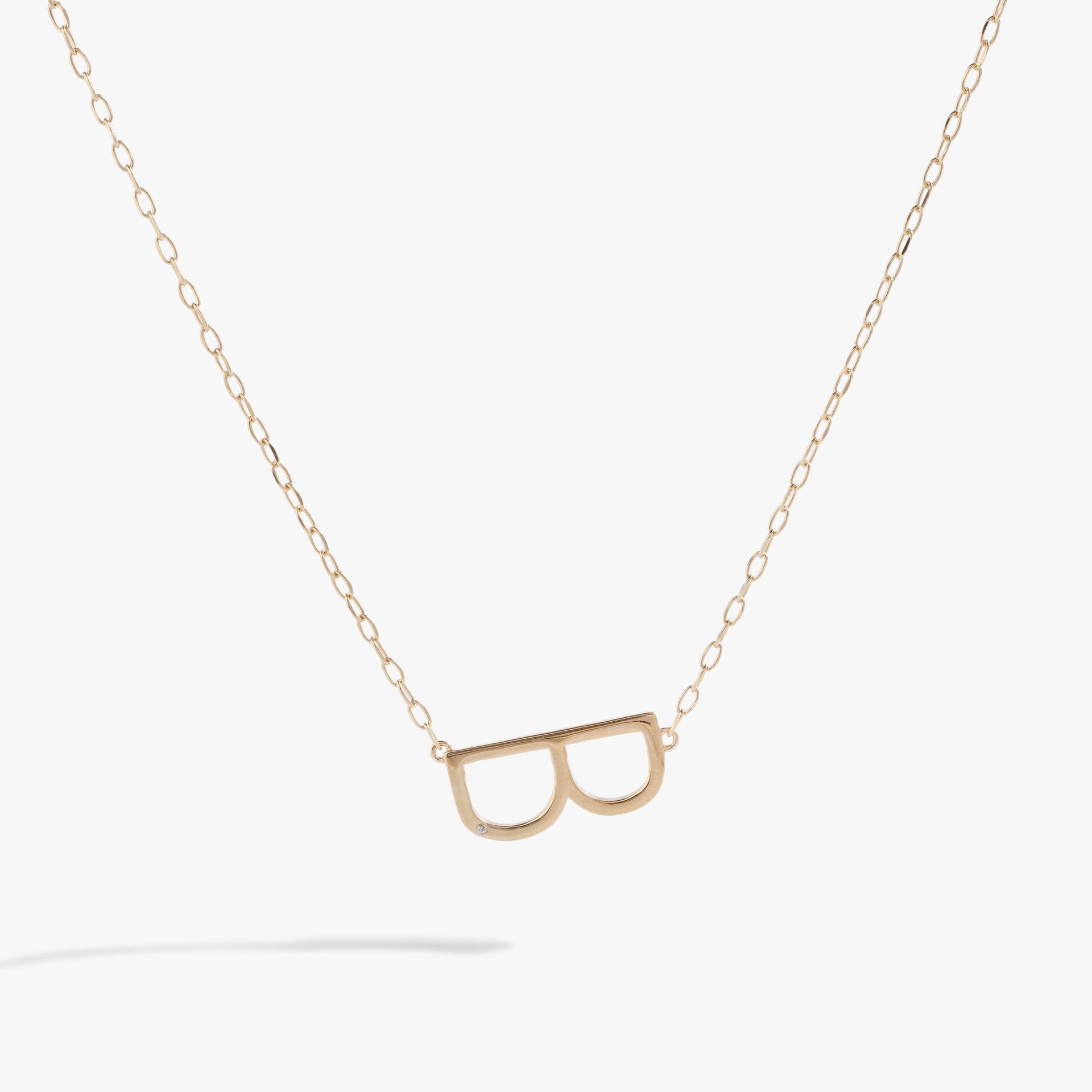 Close-up of the Initial B Precious Elongated Necklace featuring a sideways letter charm with cubic zirconia on a gold chain.