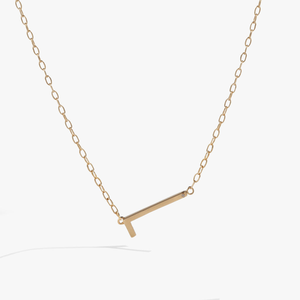 Minimalist sideways letter L necklace in metallic gold tone on a delicate chain