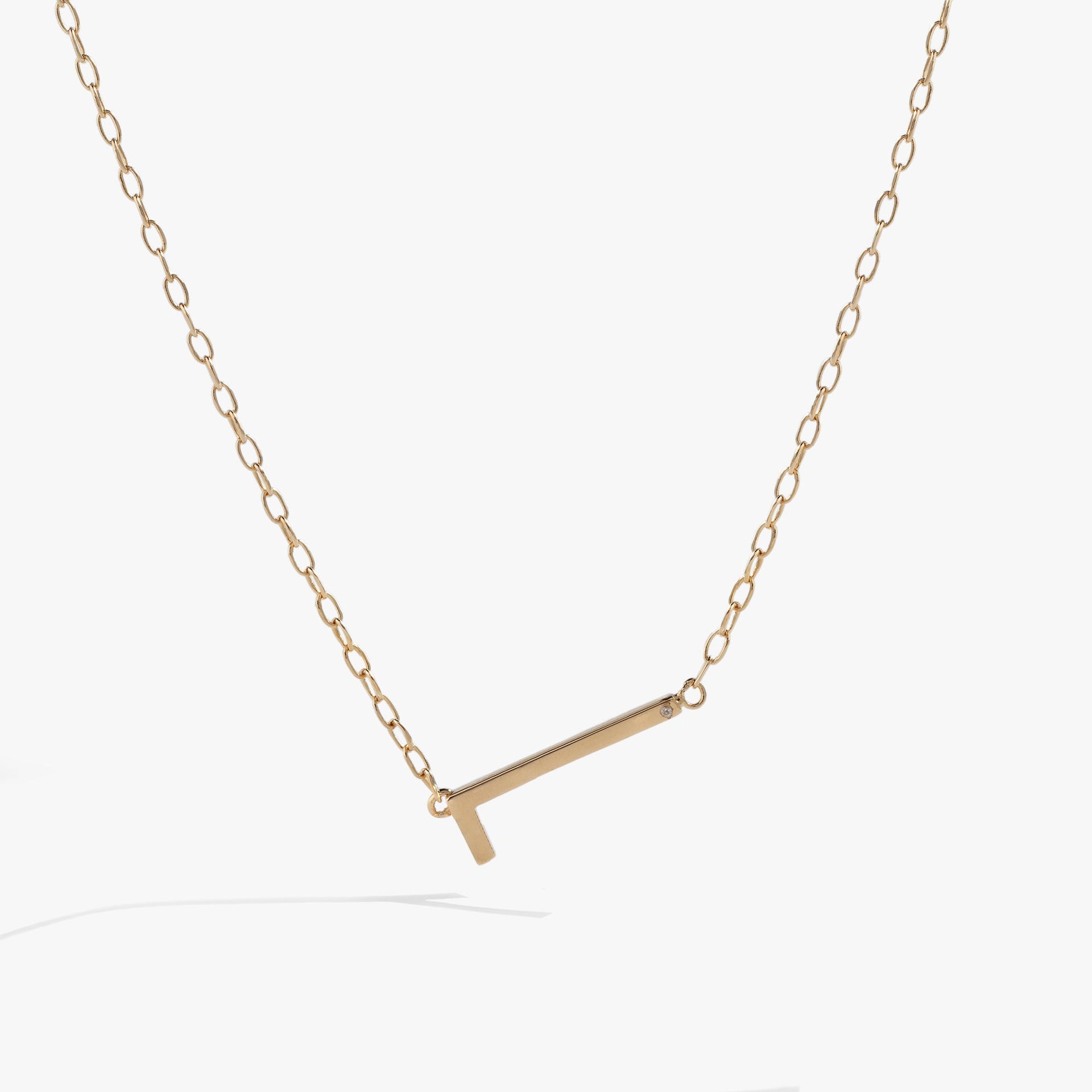 Minimalist sideways letter L necklace in metallic gold tone on a delicate chain