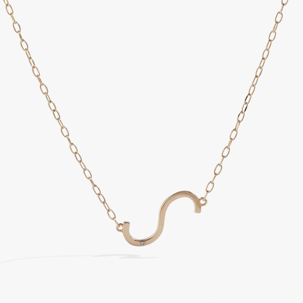 Sideways Initial S pendant necklace featuring a white CZ stone on a delicate gold chain