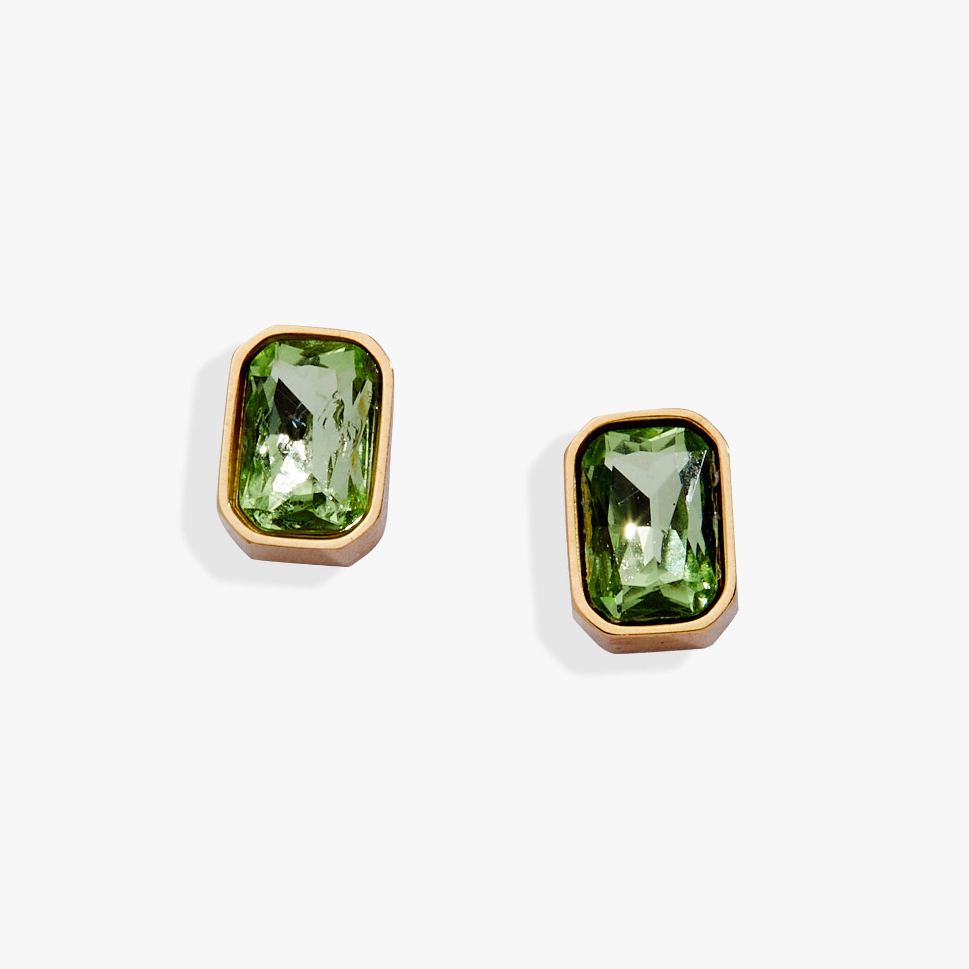 A pair of emerald-cut peridot glass stud earrings in a refined bezel setting.