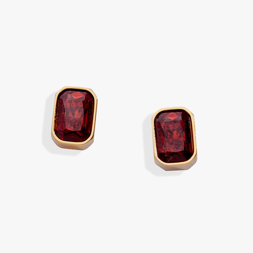 A pair of emerald-cut Siam red glass stud earrings in a polished bezel setting.