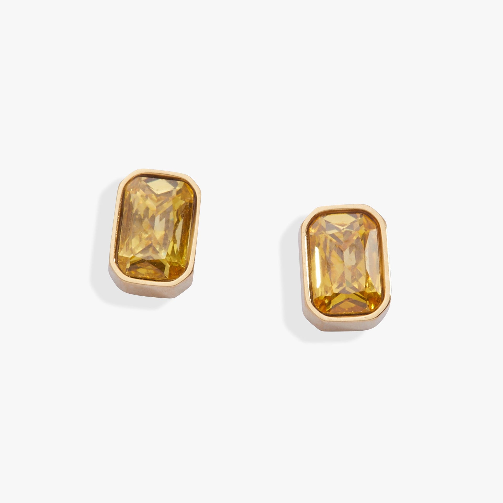 A pair of elegant emerald-cut topaz glass stud earrings in a sleek bezel setting.