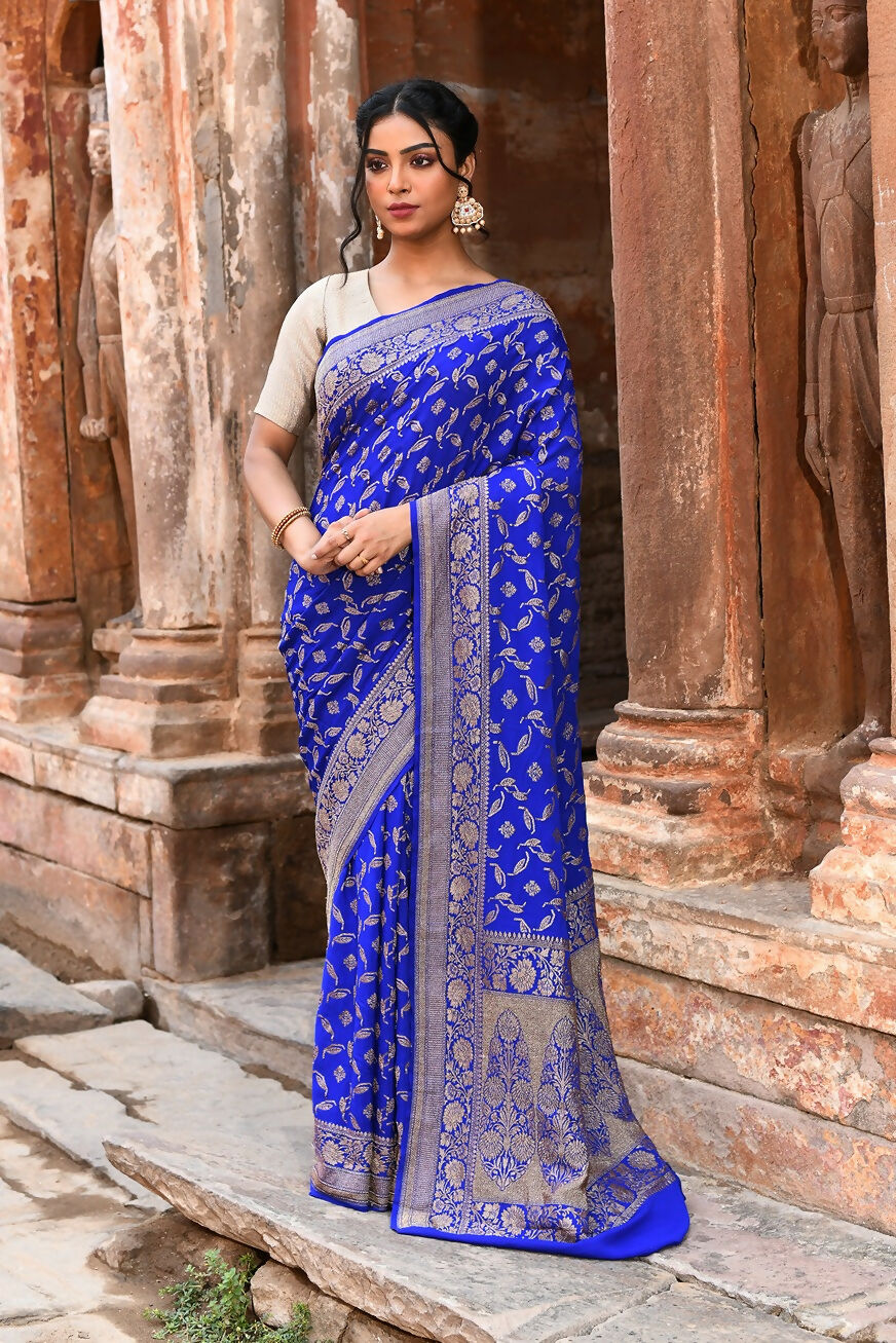 Violet Banarasi silk saree with gold zari weave draped elegantly for a formal occasion.